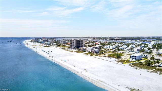 61 Mango St, Fort Myers Beach, FL 33931 Waterfront property with direct beach access, featuring a multi-story residence with multiple balconies - Virtually Edited Image