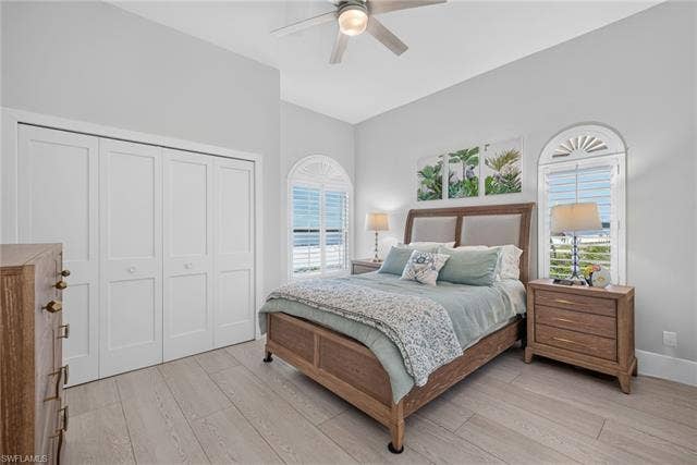 61 Mango St, Fort Myers Beach, FL 33931 Wood-finish flooring, vaulted ceiling, dual bi-fold closet doors, and arched windows with plantation shutters - Virtually Edited Image