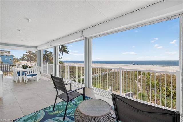 61 Mango St, Fort Myers Beach, FL 33931 Expansive covered balcony with electric hurricane shutters - Virtually Edited Image