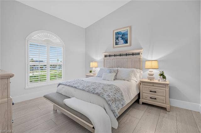 61 Mango St, Fort Myers Beach, FL 33931 Vaulted ceiling with an arched window featuring plantation shutters - Virtually Edited Image