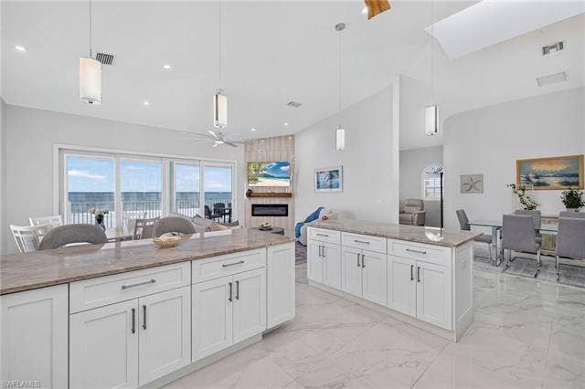 61 Mango St, Fort Myers Beach, FL 33931 Dual kitchen islands with light-toned countertops, white cabinetry, and contemporary hardware - Virtually Edited Image