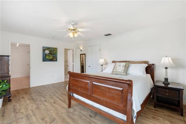 48 Fairview Blvd, Fort Myers Beach, FL 33931 Bedroom featuring light wood-type flooring and a ceiling fan - Virtually Edited Image