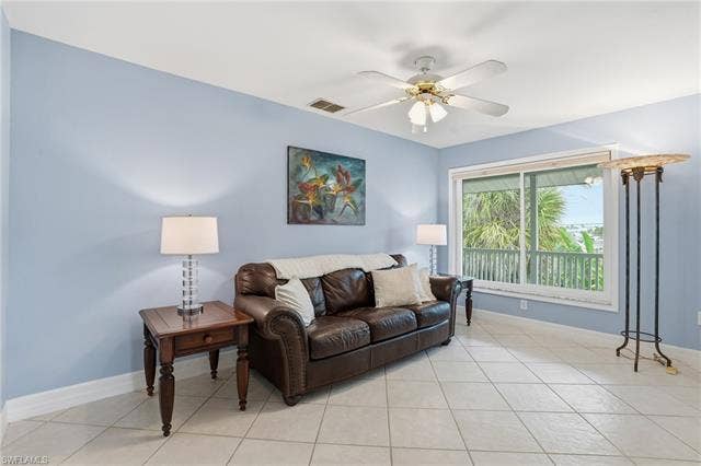 48 Fairview Blvd, Fort Myers Beach, FL 33931 Living area with ceiling fan and light tile patterned floors - Virtually Edited Image