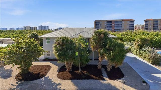 48 Fairview Blvd, Fort Myers Beach, FL 33931 View of front of property featuring a skyline view and stucco siding - Virtually Edited Image