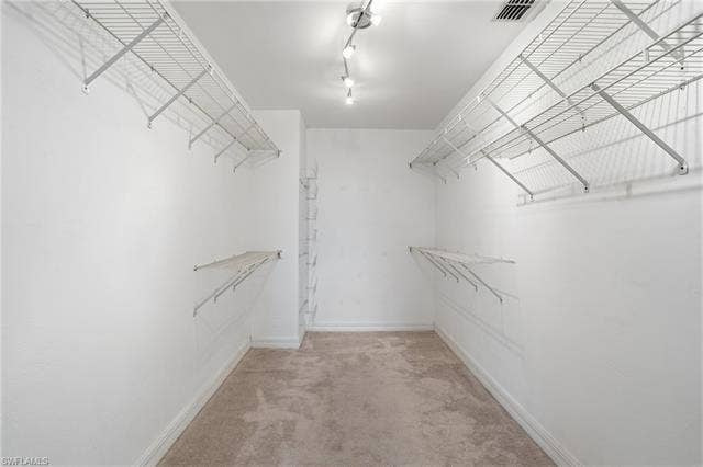 48 Fairview Blvd, Fort Myers Beach, FL 33931 Walk in closet featuring light carpet - Virtually Edited Image