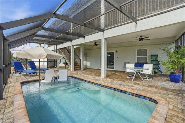 48 Fairview Blvd, Fort Myers Beach, FL 33931 Swimming pool with stairway, a lanai, a patio, and outdoor dining area - Virtually Edited Image