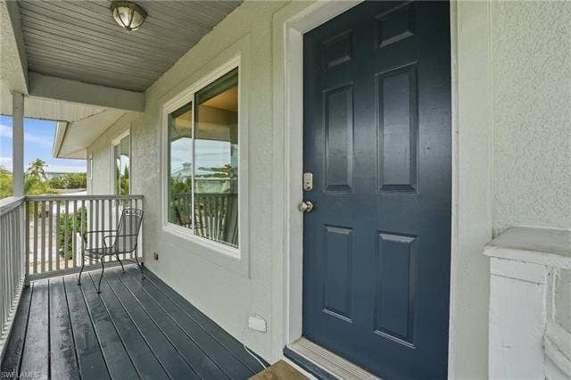 48 Fairview Blvd, Fort Myers Beach, FL 33931 Property entrance with stucco siding - Virtually Edited Image