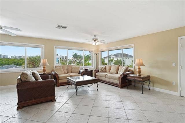 48 Fairview Blvd, Fort Myers Beach, FL 33931 Living room with ceiling fan and light tile patterned floors - Virtually Edited Image