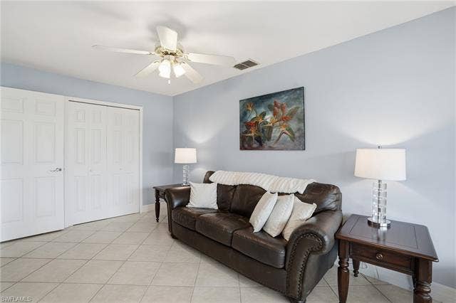 48 Fairview Blvd, Fort Myers Beach, FL 33931 Living room with light tile patterned floors and ceiling fan - Virtually Edited Image