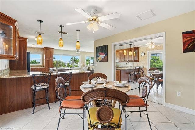 48 Fairview Blvd, Fort Myers Beach, FL 33931 Dining space with light tile patterned flooring and ceiling fan - Virtually Edited Image