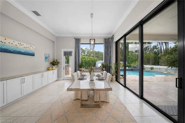 9796 Strike Ln, Bonita Springs, FL 34135 Tile flooring, extensive built-in cabinetry with stone countertops, sliding glass doors, a window with exterior access, and a visible pool
