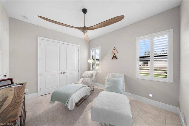 9796 Strike Ln, Bonita Springs, FL 34135 Paddle-blade ceiling fan, white paneled bifold doors, and two windows with white plantation shutters