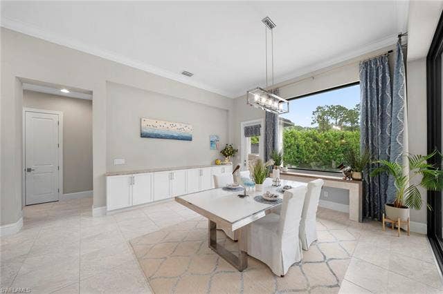 9796 Strike Ln, Bonita Springs, FL 34135 Expansive window, crown molding, built-in cabinetry, tiled flooring, and modern linear chandelier