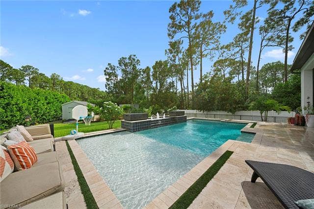 9796 Strike Ln, Bonita Springs, FL 34135 Expansive backyard featuring a multi-level swimming pool, integrated spa with water features, and a spacious paver patio