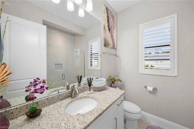 9796 Strike Ln, Bonita Springs, FL 34135 White vanity with brushed nickel hardware, speckled countertop, undermount sink, and brushed nickel faucet