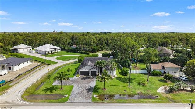 9796 Strike Ln, Bonita Springs, FL 34135 Expansive paved driveway leading to a two-car garage