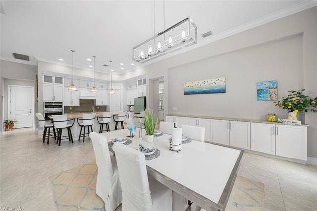 9796 Strike Ln, Bonita Springs, FL 34135 Open-concept dining and kitchen space featuring light-toned tile flooring