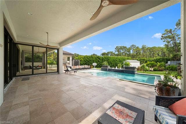 9796 Strike Ln, Bonita Springs, FL 34135 Expansive covered patio with large format tile flooring, recessed lighting, and ceiling fans