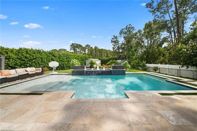 9796 Strike Ln, Bonita Springs, FL 34135 Spacious swimming pool with integrated water features and a sun shelf