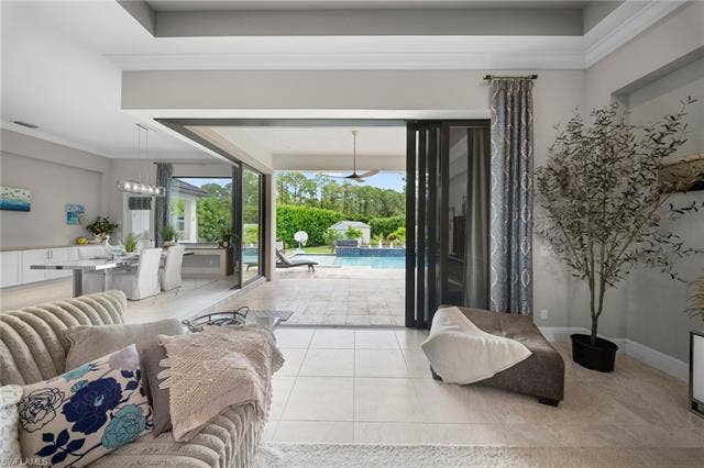 9796 Strike Ln, Bonita Springs, FL 34135 Expansive sliding glass doors open to a spacious patio with a built-in swimming pool