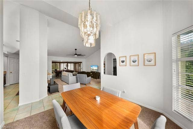 3730 21st Pl, Cape Coral, FL 33914 Vaulted ceilings, contemporary chandelier, arched wall opening, and tile flooring