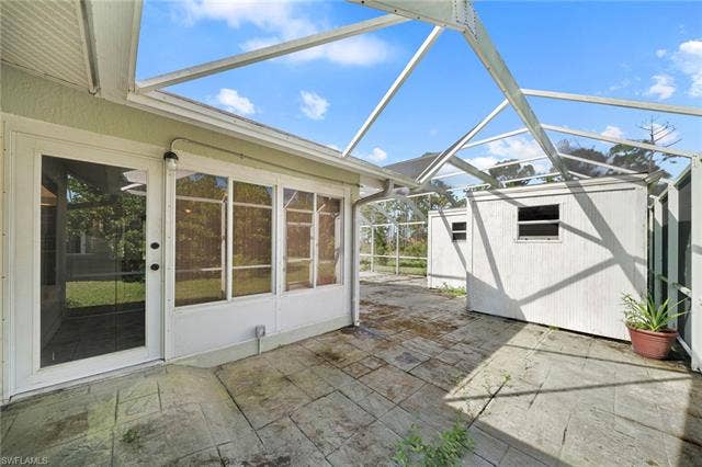 3730 21st Pl, Cape Coral, FL 33914 Screened enclosure featuring a concrete patio and a detached storage shed