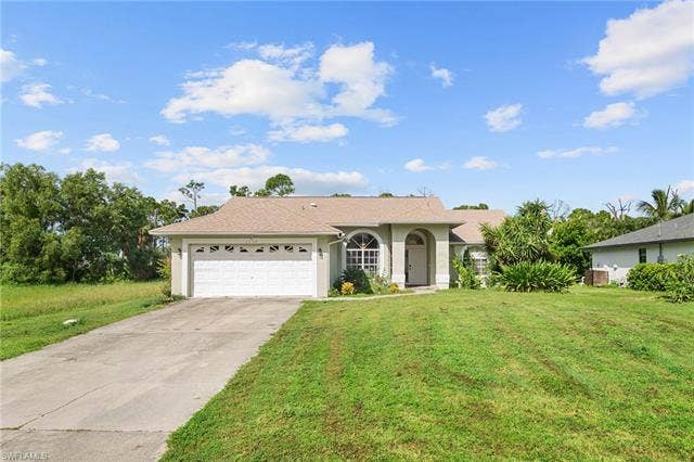 3730 21st Pl, Cape Coral, FL 33914 Single-story stucco exterior with an attached garage, arched entryway, and a prominent front lawn