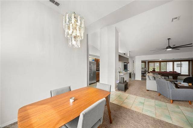 3730 21st Pl, Cape Coral, FL 33914 Vaulted ceilings with a decorative chandelier, open-concept layout, kitchen with stainless steel appliances, and a room with multiple windows