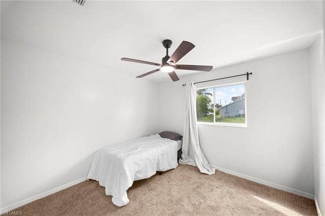 3730 21st Pl, Cape Coral, FL 33914 Neutral wall paint, brown carpet flooring, and a ceiling fan with light fixture
