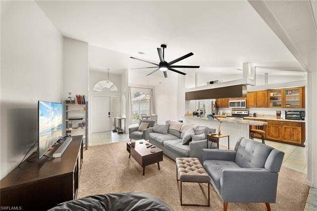 3730 21st Pl, Cape Coral, FL 33914 Vaulted ceilings, a contemporary ceiling fan, and recessed lighting illuminate this open-concept living area with carpeting