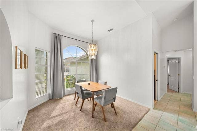3730 21st Pl, Cape Coral, FL 33914 Arched window with transom, high vaulted ceiling, and carpeted flooring