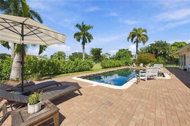 1936 Empress Ct, Naples, FL 34110 Rectangular dark-hued swimming pool and paver patio