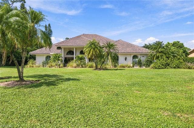 1936 Empress Ct, Naples, FL 34110 Expansive front lawn, almost 1 Acre Lot with mature palm trees
