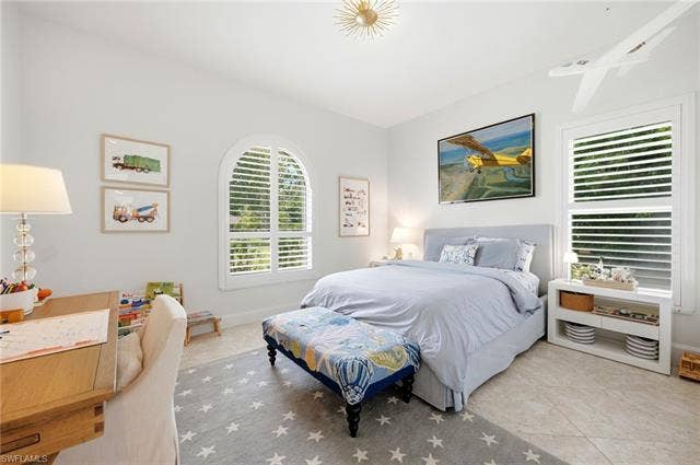 1936 Empress Ct, Naples, FL 34110 Arched window with plantation shutters, additional window with plantation shutters, overhead light fixture, light-toned flooring, built-in shelving