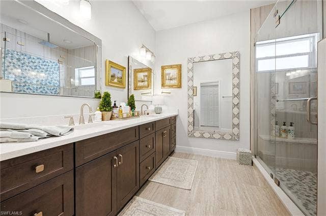 1936 Empress Ct, Naples, FL 34110 Dual vanity with a white countertop and wood-finish cabinetry, walk in shower