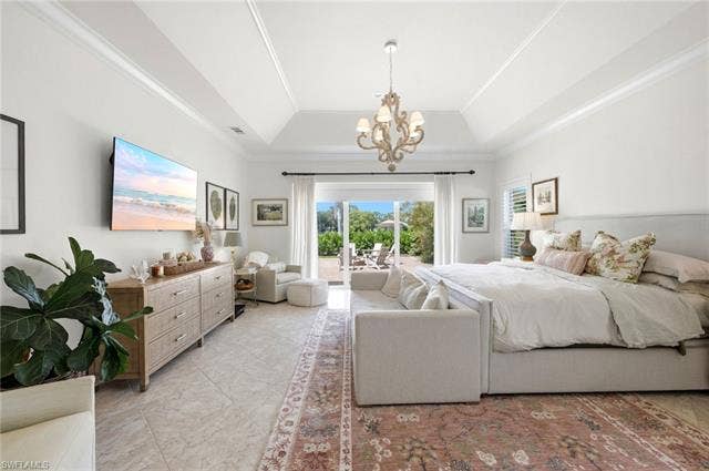 1936 Empress Ct, Naples, FL 34110 Spacious Primary Bedroom with tray ceiling, crown molding, tiled flooring, chandelier lighting, and direct outdoor access