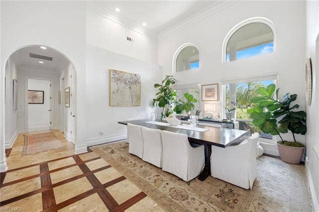 1936 Empress Ct, Naples, FL 34110 Soaring ceilings with arched windows, recessed lighting, and a patterned tile and wood-finish flooring
