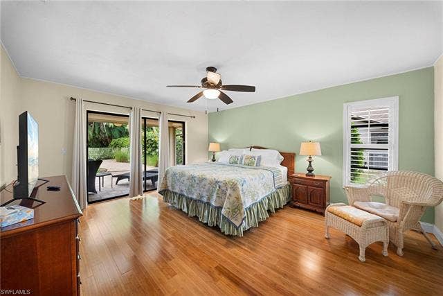 2171 Kings Lake Blvd, Naples, FL 34112 Wood-finish flooring throughout, ceiling fan with integrated lighting, sliding glass door patio access, and a window with plantation shutters