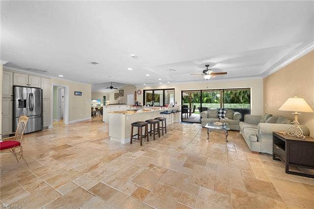 2171 Kings Lake Blvd, Naples, FL 34112 Expansive living area with large-format stone tile flooring, crown molding, and recessed lighting
