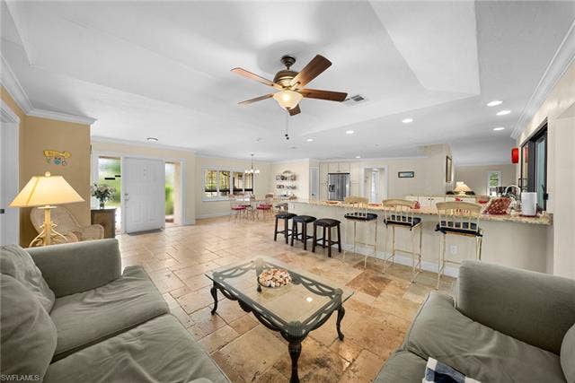 2171 Kings Lake Blvd, Naples, FL 34112 Recessed lighting, ceiling fan, crown molding, tile flooring, and a kitchen island with seating