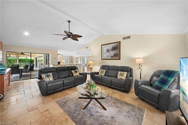 2171 Kings Lake Blvd, Naples, FL 34112 Varnished wood-finish ceiling fan, vaulted ceiling, tile flooring, sliding glass doors, and a built-in counter with cabinetry