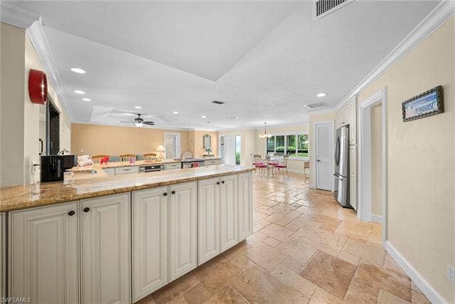 2171 Kings Lake Blvd, Naples, FL 34112 Kitchen featuring light-toned cabinetry, granite countertops, stainless steel refrigerator, and large format floor tiling