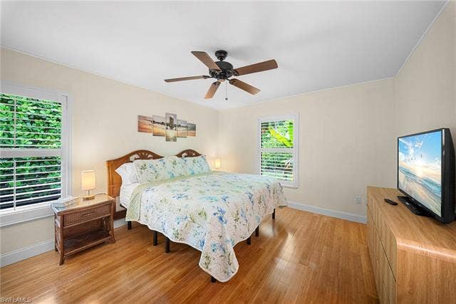 2171 Kings Lake Blvd, Naples, FL 34112 Wood-finish flooring, ceiling fan, and two windows with horizontal blinds