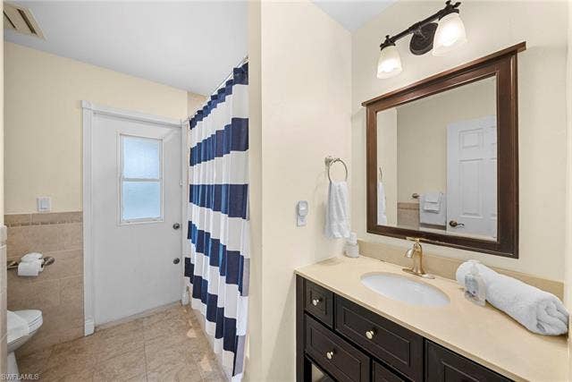 2171 Kings Lake Blvd, Naples, FL 34112 Single vanity with an undermount sink, a dark wood-finish cabinet, and a framed mirror