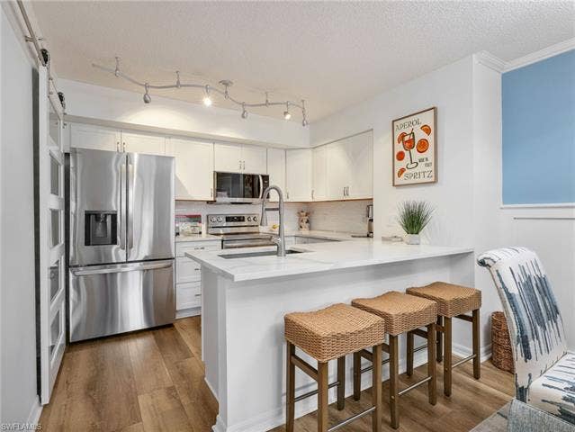 8659 River Homes Ln, #1202, Bonita Springs, FL 34135 LG appliances, subway tile backsplash, quartz countertops, breakfast bar