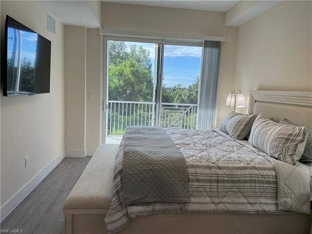 26600 Rosewood Pointe Dr, #B-107, Bonita Springs, FL 34135 Bedroom with hardwood / wood-style floors and access to outside