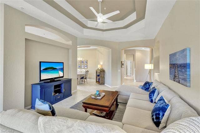10060 Valiant Ct, #202, Miromar Lakes, FL 33913 Recessed tray ceiling with ceiling fan, tile flooring, and arched wall openings