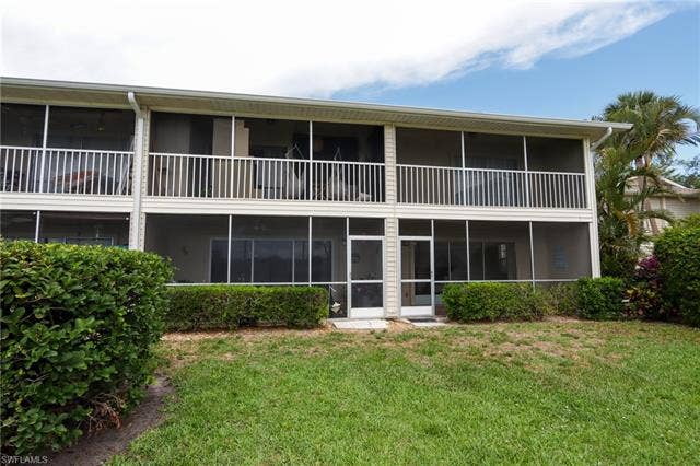 25484 Cockleshell Dr, #901, Bonita Springs, FL 34135 Back of house featuring a yard and a sunroom