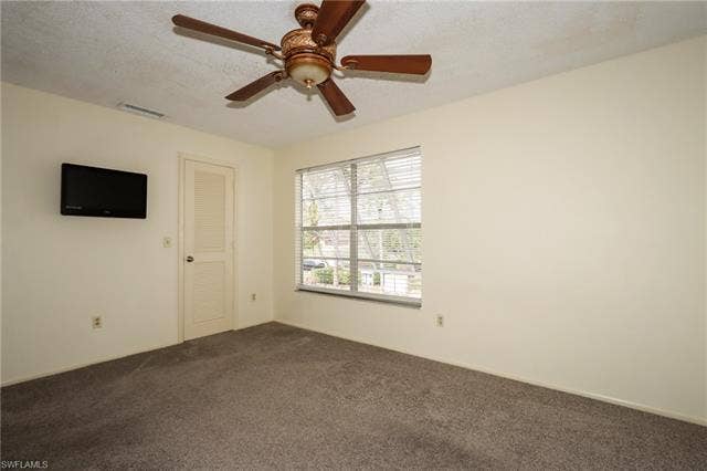 25484 Cockleshell Dr, #901, Bonita Springs, FL 34135 Spare room with dark colored carpet and a ceiling fan