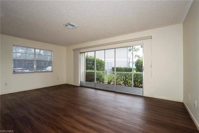 25484 Cockleshell Dr, #901, Bonita Springs, FL 34135 Spare room with a textured ceiling and dark wood finished floors